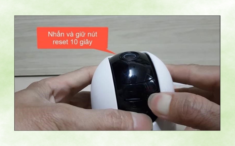nhấn và giữ nút Reset trên thân camera